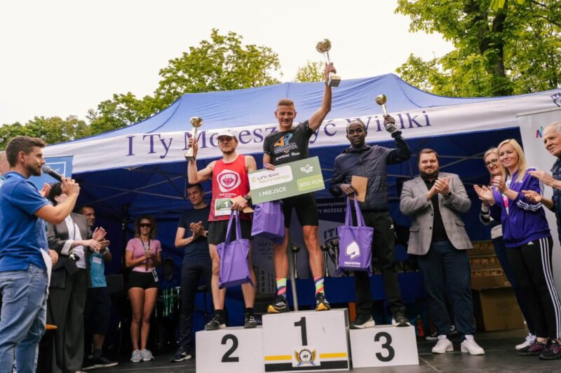 Zwycięscy biegu ustawieni na podium z&nbsp;pucharami i&nbsp;nagrodami.