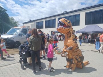 Dinozaur częstujący dzieci cukierkami