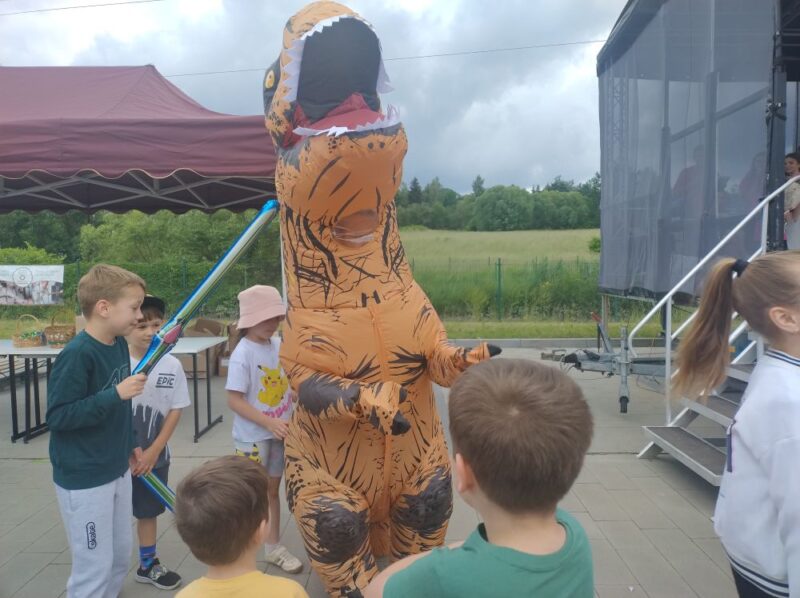 Osoba w&nbsp;przebraniu dinozaura z&nbsp;dziećmi